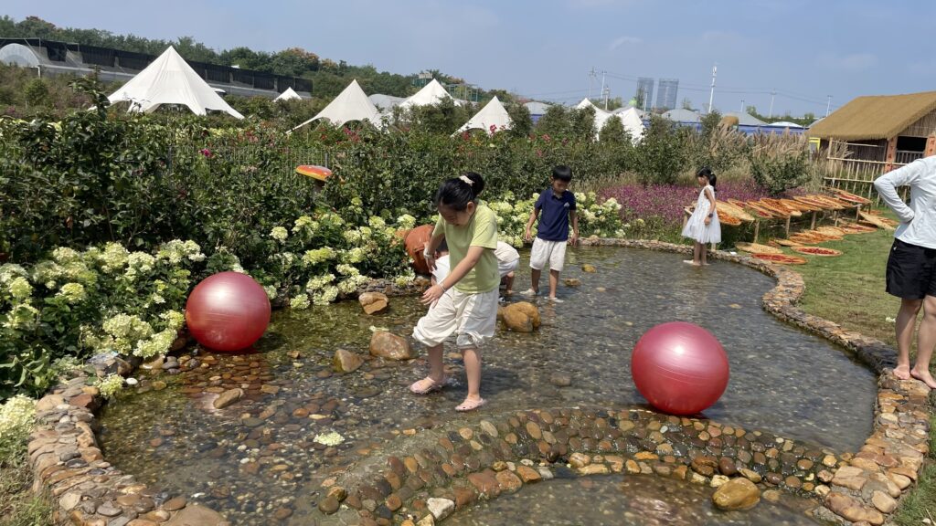 Child playing in a shallow water area at a family farm in Changsha