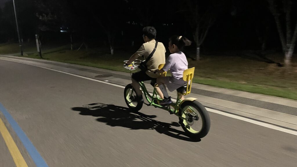A father riding with his daughter around Songya Lake