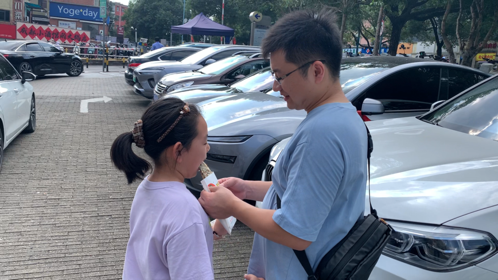 A child’s hands holding a second meicai kourou pie, the family’s favorite Chinese street food