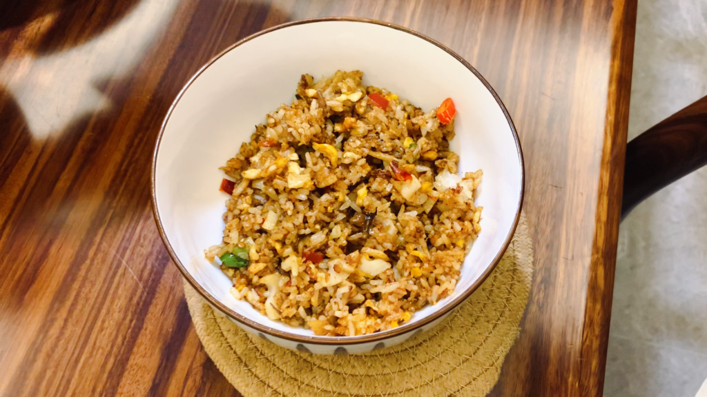 Lotus root and egg fried rice cooking in a wok at home