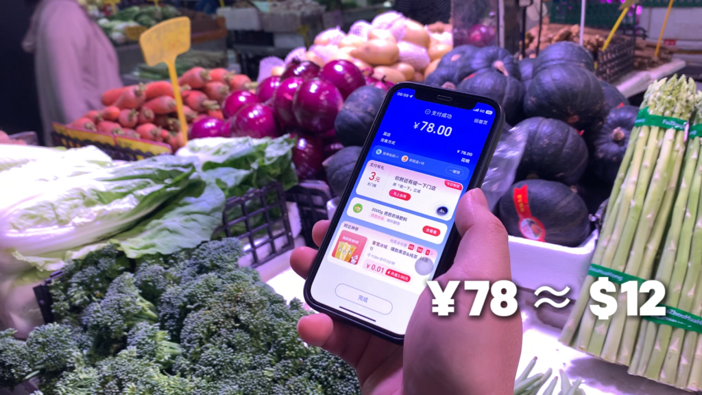 Scanning a seller’s QR code with a phone to pay at a Chinese wet market