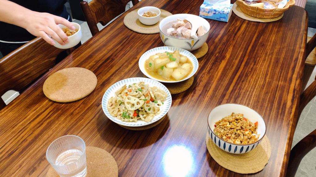 Chinese family dinner with four shared dishes in the middle of the table
