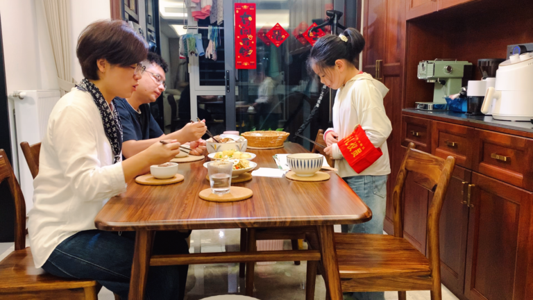 Family of three eating a homemade dinner together in Hunan, China