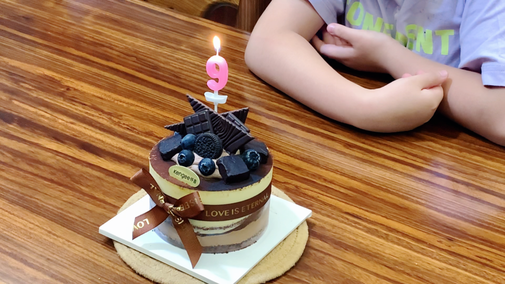 Birthday cake with a lit candle at the end of a lunar birthday in China